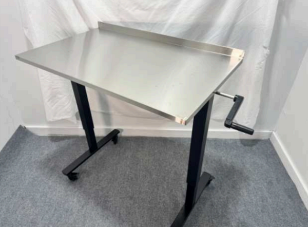 Over-the-patient instrument table with stainless steel top and manual hand crank height adjustment, rolls over any surgery table